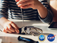 female putting together a robot hand with NSF NASA logos placed on top